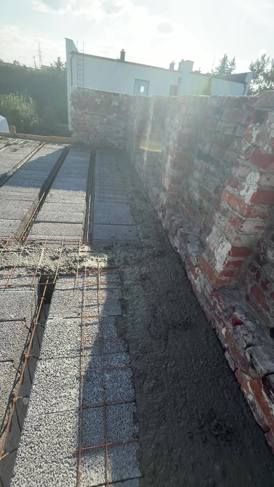 Wylewanie betonu na dachu płaskim między attykami