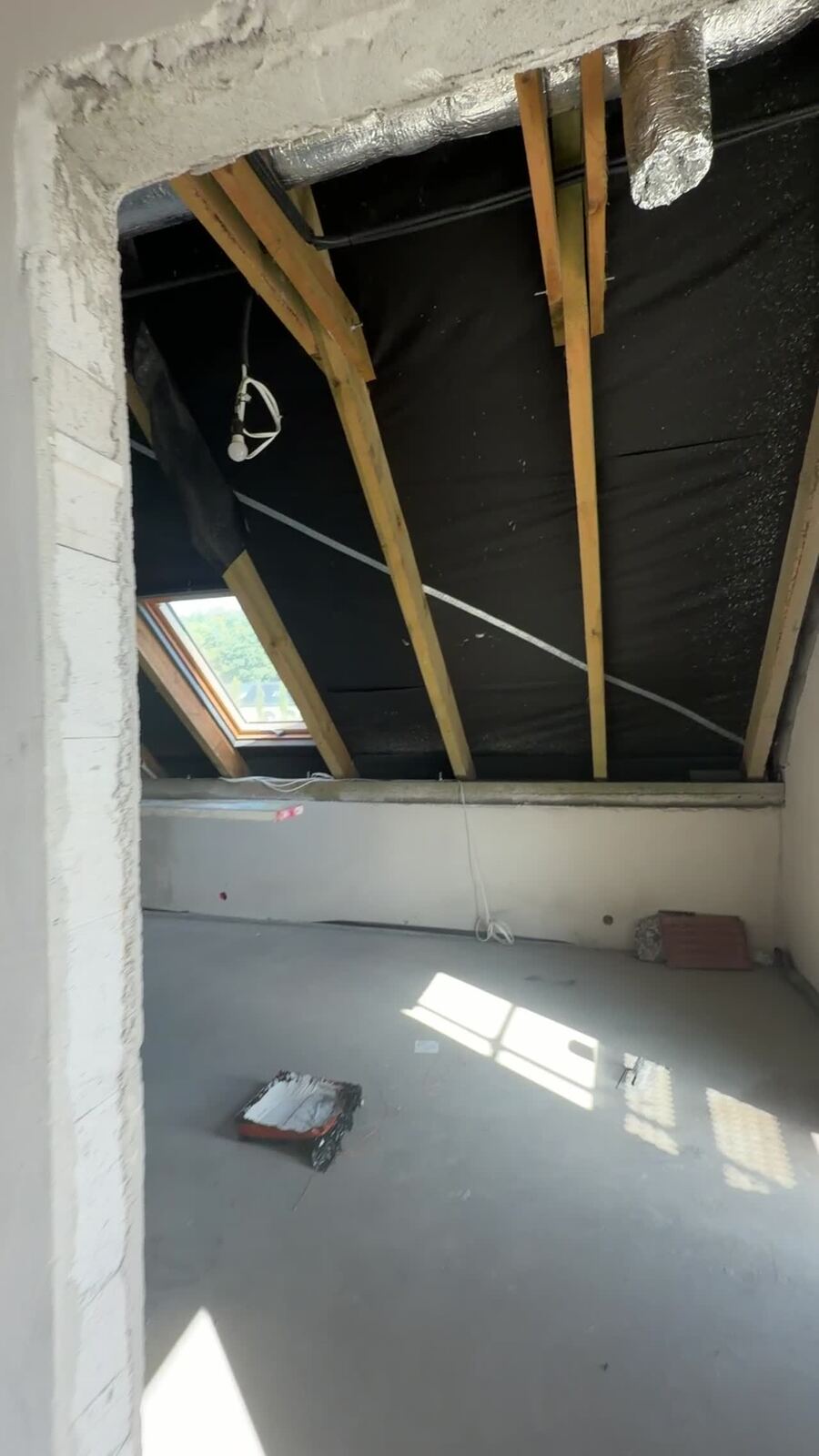 Korytarz w trakcie wykończenia z widocznymi instalacjami
